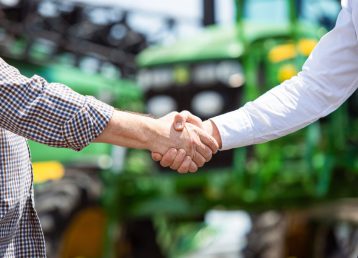 A farmer with a tractor, combine at a field in sunlight. Confident, bright colors A farmer with a tractor, combine at a field in sunlight. Confident, bright colors